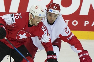 Švajčiarsky hokejista Sven Andrighetto(vľavo) a ruský hokejista Igor Ožiganov v zápase A-skupiny Švajčiarsko - Rusko.