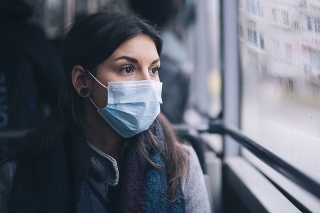 Young woman wearing protective face mask, she sitting in bus transportation in the city.