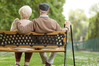 Rear view shot of a senior couple sitting on a wooden bench in the park