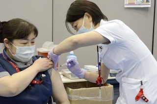 Zdravotná sestra dostáva prvú dávku vakcíny proti ochoreniu COVID-19
