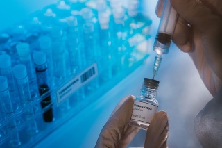 Doctor preparing the coronavirus COVID-19 vaccine. Details of hands and syringe.