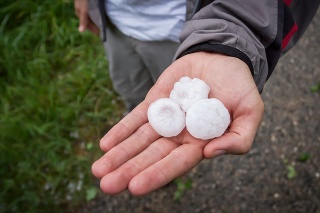 A man showing large hailstones in his hand.