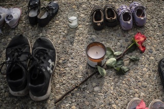 Detské topánky, tenistky a červená ruža sú na chodníku na pamiatku viac než 200 detí, ktorých pozostatky objavili v masovom hrobe.