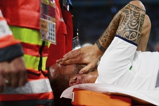Zranený taliansky futbalista Leonardo Spinazzola, ktorého odnášajú na nosidlách, si zakrýva tvár vo štvrťfinálovom zápase Belgicko - Taliansko na EURO 2020 vo futbale v Mníchove 2. júla 2021.