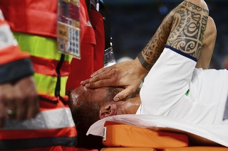 Zranený taliansky futbalista Leonardo Spinazzola, ktorého odnášajú na nosidlách, si zakrýva tvár vo štvrťfinálovom zápase Belgicko - Taliansko na EURO 2020 vo futbale v Mníchove 2. júla 2021.