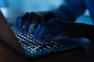 close up programmer man hand typing on keyboard laptop for register data system or access password at dark operation room , cyber security concept