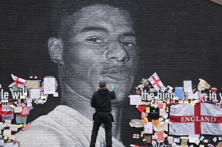 Pouličný umelec Akse P19 robí opravy na nástennej maľbe, ktorá zobrazuje anglického futbalového reprezentanta Marcusa Rashforda.