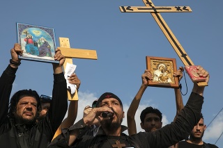 Odporcovia očkovania držia kríže a ikony počas protestu v centre Atén.