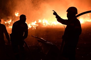 Hasiči hasia lesný požiar v oblasti Adames na severnom predmestí Atén.