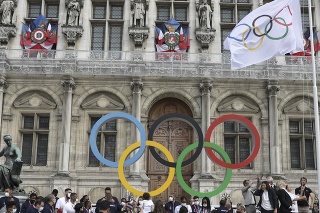 Starostka Paríža Anne Hidalgová vztyčuje olympijskú vlajku pred radnicou v Paríži.