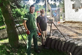 Ľubomír (36) a Stanislav (58) pomáhajú
pri oprave chodníka pri dome smútku v Dobrej Nive.