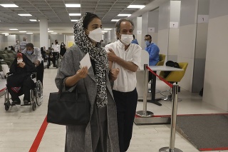 Ľudia odchádzajú z nákupného centra v Teheráne v Iráne po tom, ako ich zaočkovali proti COVID-19. 