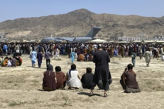 Ľudia sa zhromažďujú neďaleko amerického transportného lietadla C-17 na medzinárodnom letisku  Hámida Karzaja v Kábule v utorok 17. augusta 2021. 