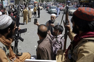 Afganci si fotia selfie s bojovníkmi Talibanu, ktorí hliadkujú na ulici v Kábule 19. augusta 2021.