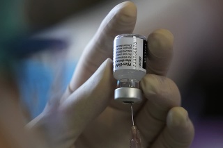 Zdravotníčka pripravuje ampulku s vakcínou Pfizer-BioNTech
