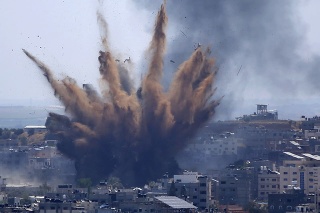 Po izraelských náletoch na budovu v Gaze vo štvrtok 13. mája 2021 stúpa dym. 