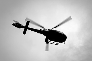 Black and white silhouette of helicopter from low angle view