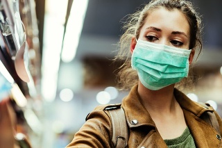 Young woman with face mask using mobile phone and buying groceries in the supermarket during virus pandemic.