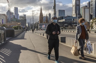 Ľudia s ochrannými rúškami cestou z centrálnej obchodnej štvrte v Melbourne 5. augusta 2020.