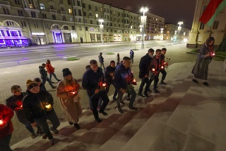 Ľudia kladú sviečky pred sídlom KGB v Minsku.