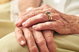 Cropped shot of an elderly woman’s hands resting on her lap