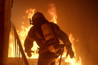 Brave Firefighter Runs Up The Stairs. Raging Fire is Seen Everywhere.