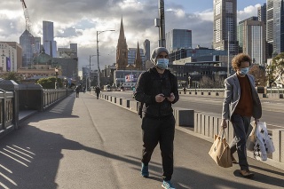 Ľudia s ochrannými rúškami cestou z centrálnej obchodnej štvrte v Melbourne 5. augusta 2020.