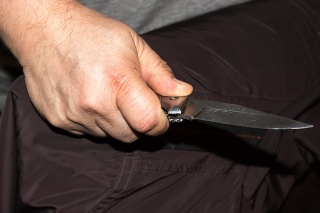 Closeup of a young man hand, holding a knife, about to attack,