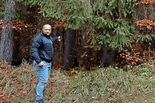 Policajt Dušan ukazuje na les, kde boli na prechádzke.