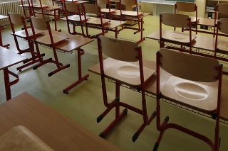 Učiteľka sedí v prázdnej triede a pripravuje si materiály pre žiakov počas dištančnej výučby na škole v Prahe.