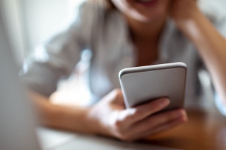 Close up of a young woman using her phone at home