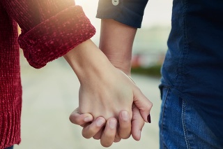 Cropped shot of a couple holding hands outdoors