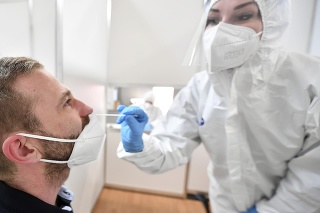 Zdravotníčka odoberá vzorku mužovi počas testovania na ochorenie COVID-19 v nemeckom Erfurte.