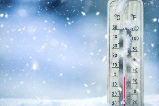Thermometer on snow shows low temperatures - zero. Low temperatures in degrees Celsius and fahrenheit. Cold winter weather - zero celsius thirty two farenheit.