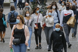 Ľudia sa prechádzajú s rúškami na tvári v uliciach Francúzska. 