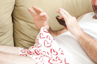 Humorous photo of a man in his underwear, using his cellphone to send a picture of his penis.