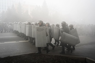 Poriadková polícia kráča, aby zablokovala demonštrantov počas protestu v Almaty.