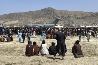 Ľudia sa zhromažďujú neďaleko amerického transportného lietadla C-17 na medzinárodnom letisku  Hámida Karzaja v Kábule v utorok 17. augusta 2021. 