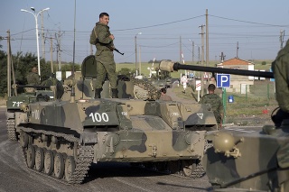 Ruskí vojaci na pásových obrnených vozidlách pred železničným prejazdom asi 30 kilometrov od hraníc s Ukrajinou.