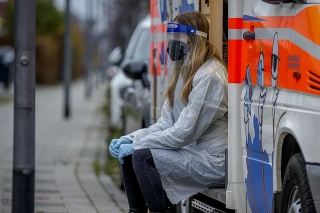 Zdravotná pracovníčka pred mobilnou testovacou dodávkou vo Frankfurte.
