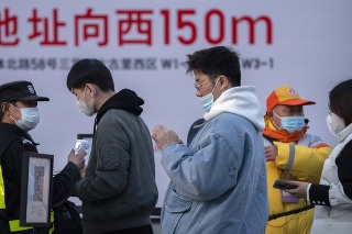 Ľudia s rúškami v Pekingu.