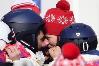 Na snímke uprostred slovenská lyžiarka Petra Vlhová oslavuje v cieli s bratom Borisom Vlhom (vľavo) po tom, ako získala zlato v 2.kole slalomu žien v alpskom lyžovaní na ZOH 2022 v Pekingu.