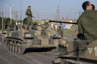 Ruskí vojaci na pásových obrnených vozidlách pred železničným priecestím asi 30 kilometrov od hraníc s Ukrajinou.