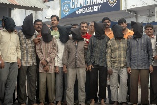 Deväť mužov s čiernymi kapucňami, ktoré zakrývajú svoju identitu, zatknutí za údajné vykonanie série bombových útokov, sú predvedení pre médiá v Ahmadabáde v Indii v sobotu 16. augusta 2008.
