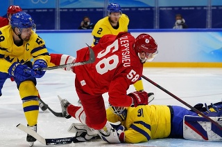 Na snímke druhý sprava hore ruský útočník Anton Stepyšev a vpravo dole švédsky brankár Lars Johansson v semifinále olympijského turnaja. 
