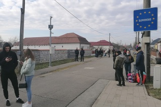 Na snímke ľudia čakajúci na svojich príbuzných a známych z Ukrajiny na slovenskej strane hraničného priechodu pre peších v obci Veľké Slemence.