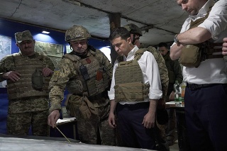 Ukrajinský prezident Volodymyr Zelenskij (uprostred) počúva vojenských predstaviteľov počas návštevy vojnou postihnutého regiónu.