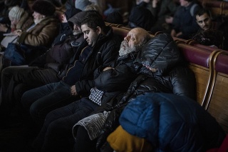 Ľudia, ktorí sa snažia utiecť z Ukrajiny, spia v preplnenej železničnej stanici Ľvov.