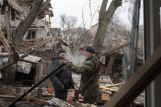 Andrey Goncharuk (vpravo), člen územnej obrany hovorí s mužom na dvore domu poškodeného ruským náletom v Gorenke, mimo hlavného mesta Kyjev v stredu 2. marca 2022.