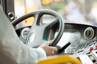 Hands of driver in a modern bus by driving.Concept - close-up of bus driver steering wheel and driving passenger bus